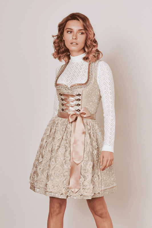 Das Dirndl Edina glänzt mit vielen Borten entlang des Dekolletés. Die transparente Spitzenschürze mit Perlenstickerei ist das Highlight des Dirndls. Perfekt abgestimmte Miederhaken mit passender Schnürung runden das Outfit ab.