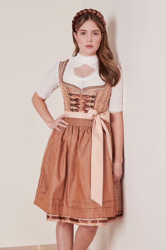 Unser traitionelles Dirndl Inken (60cm) aus der verspielten MADL Kollektion vereint klassischen Stil mit elegantem Charme. Das floral gemusterte Design und der taillierte Schnitt schmeicheln deiner Figur und setzen sie optimal in Szene. Der Rock hat eine Länge von 60cm und endet knielang