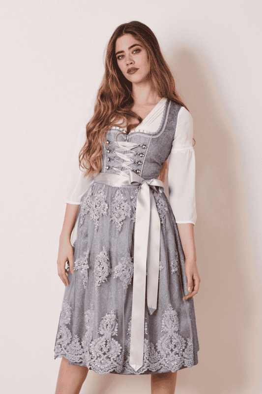 Das traumhafte Dirndl Ruth begeistert mit einem eleganten Look. Das Ornamentenmuster des Dirndls harmoniert hervorragend mit der perlenbesetzten und transparenten Spitzenschürze.