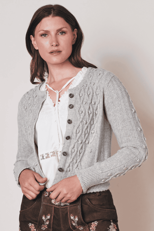 Liebliche Trachtenjacke. Die Trachtenjacke Wanda überzeugt durch einen klassischen Schnitt und ein schönes Zopfmuster. Sie passt perfekt zum Dirndl oder zur Lederhose und auch im Alltag ist die Strickjacke sehr vielseitig zu kombinieren.