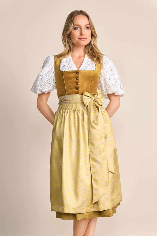 Das hinreißende Dirndl Tuana zeichnet sich durch sein Samtmieder und die aufregende Schürze aus. Es ist tailliert geschnitten und betont so charmant deine Figur. Der Rock reicht unter das Knie