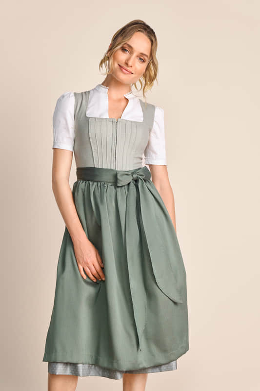 Das Modell Margit sorgt für einen wundervollen Auftritt. Mit diesem Dirndl wird seine Trägerin zu dem Eyecatcher auf jedem Event. Für dieses elegante Dirndlkleid wurde das Mieder schlicht und ohne Muster gehalten. Der Rockteil besticht durch das zarte Ornament Muster und die schlichte Schürze runet den gesamt Look romantisch ab. Das Dirndl wird ohne Schnürung mit einem Häkchenverschluss geschlossen. Mit dem Dirndl Margit bist du immer perfekt gekleidet!